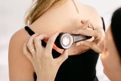 Dermatologist discussing mole removal procedure and pricing with a patient in a clinic setting